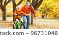 Happy family grandfather teaches child grandson  to ride a bike in park 96731048