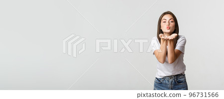 Tender attractive young woman blowing air kiss at camera flirty 96731566