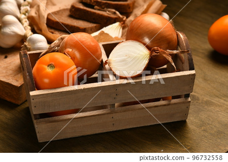 still life of food in a rural style on a dark wood background, rye bread and garlic, tomatoes and onion, concept of fresh vegetables and healthy food 96732558