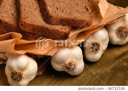 still life of food in a rural style on a dark wood background, rye bread and garlic, concept of fresh vegetables and healthy food still life of food in a rural style on a dark wood background, rye bread and garlic, concept of fresh vegetables and healthy food 96732580