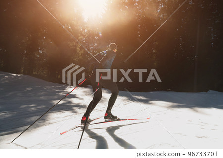 Nordic skiing or Cross-country skiing classic technique practiced by man in a beautiful panoramic trail at morning. 96733701