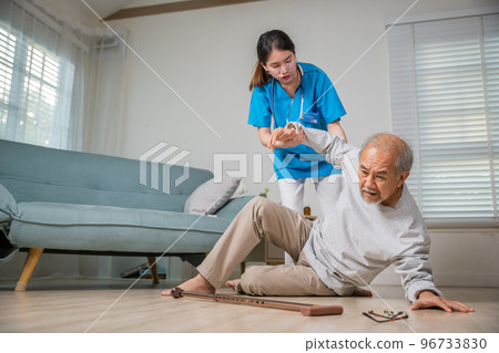Asian older senior man falling down on lying floor and woman nurse came to help support, Disabled elderly old man patient fall down and caring young assistant at nursing home 96733830