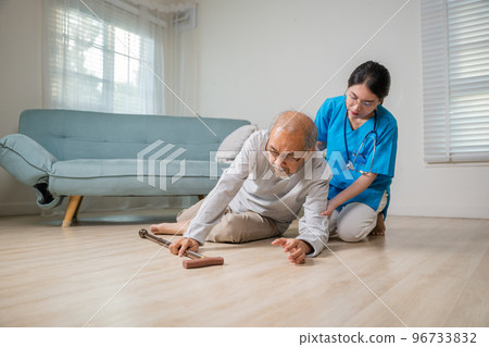 Disabled elderly old man patient with walking stick fall on floor and caring young assistant at nursing home, Asian older senior man falling down on lying floor and woman nurse came to help support 96733832