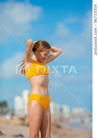 Adorable girl on the beach in swimsuit Adorable girl on the beach in swimsuit 96735059