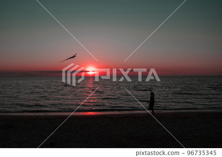 happy girl running with a kite at sunset outdoors. A child runs with a kite at sunset against the backdrop of the sea. Family vacation. High quality photo. happy girl running with a kite at sunset outdoors. A child runs with a kite at sunset against the backdrop of the sea. Family vacation. High quality photo. 96735345