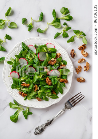 Lambs lettuce, radish and walnuts salad.  96736135
