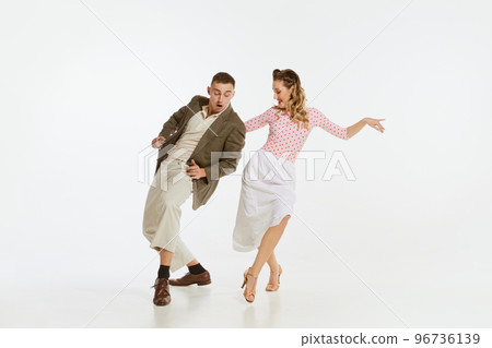 Young excited man and woman in 60s american fashion style clothes dancing retro dance isolated on white background. Music, energy, happiness, mood, action 96736139
