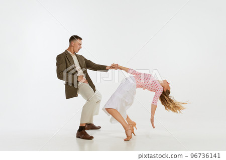 Young excited man and woman in 60s american fashion style clothes dancing retro dance isolated on white background. Music, energy, happiness, mood, action 96736141
