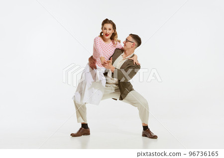 Dynamic portrait of happy, stylish and energetic dancers dancing lindy hop or swing dance isolated on white background. Music, energy, happiness, mood, action 96736165