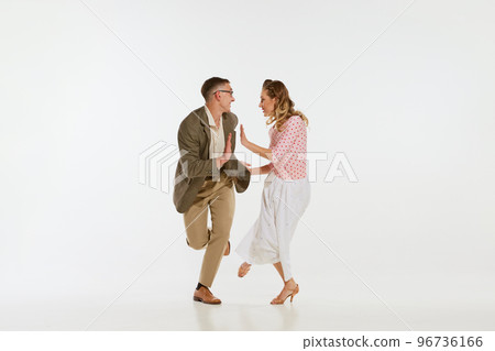 Young excited man and woman in 60s american fashion style clothes dancing retro dance isolated on white background. Music, energy, happiness, mood, action 96736166
