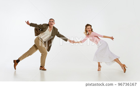 Two emotional dancers in vintage style clothes dancing swing dance, rock-and-roll or lindy hop isolated on white background. 1960s american fashion style and art. Two emotional dancers in vintage style clothes dancing swing dance, rock-and-roll or lindy hop isolated on white background. 1960s american fashion style and art. 96736167