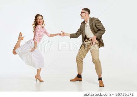 Two emotional dancers in vintage style clothes dancing swing dance, rock-and-roll or lindy hop isolated on white background. 1960s american fashion style and art. Two emotional dancers in vintage style clothes dancing swing dance, rock-and-roll or lindy hop isolated on white background. 1960s american fashion style and art. 96736171