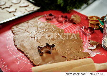 raw rolled dough for ginger cookies with cutter in shape of man. Traditional sweets for winter holidays 96737400