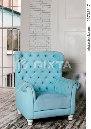 Comfortable soft blue armchair in a bright interior Comfortable soft blue armchair in a bright interior 96738247