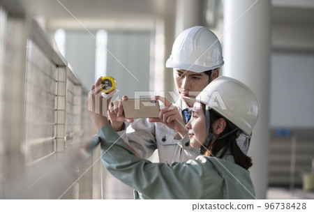 Young male and female engineers doing field survey Young male and female engineers doing field survey 96738428