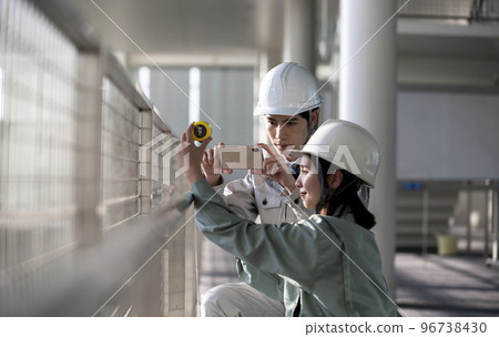Young male and female engineers doing field survey 96738430