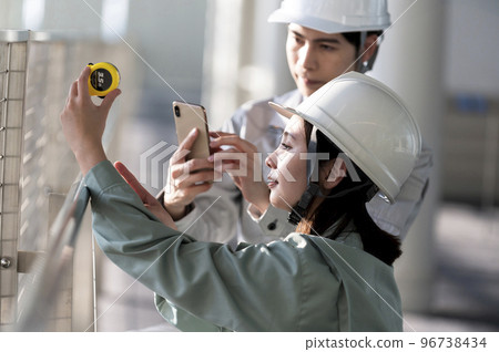 Young male and female engineers doing field survey 96738434