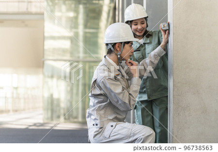 一名男初級工程師在一名女高級工程師的指導下工作 96738563