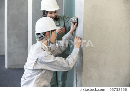 一名男初級工程師在一名女高級工程師的指導下工作 96738566