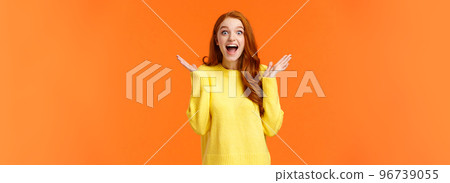 Holidays, surprise and fashion concept. Happy cheerful redhead female customer shopaholic, excited see christmas sales, smiling amused, clap hands from thrill and joy, standing orange background Holidays, surprise and fashion concept. Happy cheerful redhead female customer shopaholic, excited see christmas sales, smiling amused, clap hands from thrill and joy, standing orange background 96739055