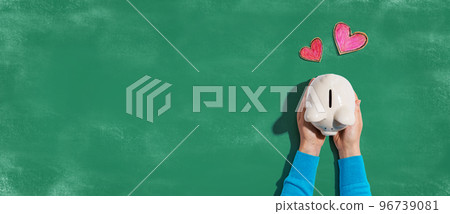 Person holding piggy bank with hearts 96739081