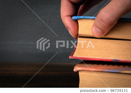 Stack of books and a woman's hand 96739131