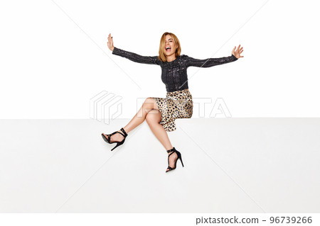 blonde woman with long legs sitting on white bench. blonde woman with long legs sitting on white bench. 96739266
