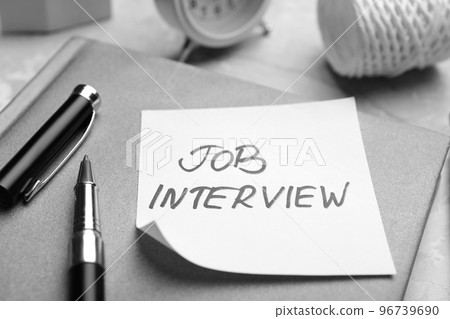 Reminder note about job interview and stationery on table, closeup 96739690
