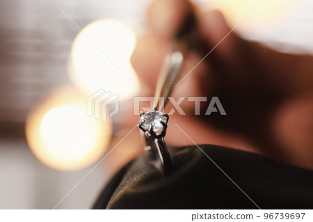 Professional jeweler working with beautiful ring indoors, closeup 96739697