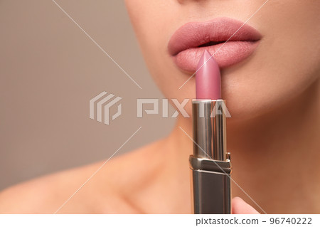 Woman with pink lipstick on brown background, closeup Woman with pink lipstick on brown background, closeup 96740222