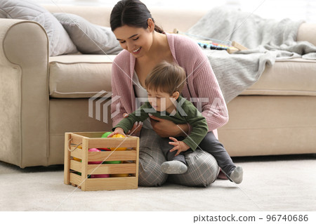 Young nanny and cute little baby playing with toys at home 96740686