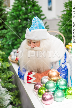 Russian santa claus holds decorations for the christmas tree in the store. 96741639