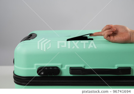 A woman demonstrates a broken suitcase on a white background. Damaged baggage during the flight. A woman demonstrates a broken suitcase on a white background. Damaged baggage during the flight. 96741694