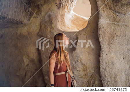 Young woman exploring valley with rock formations and fairy caves near Goreme in Cappadocia Turkey 96741875