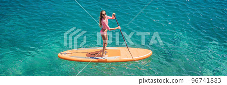 BANNER, LONG FORMAT Young women Having Fun Stand Up Paddling in blue water sea in Montenegro. SUP. girl Training on Paddle Board near the rocks Portrait of a disgruntled girl sitting at a cafe table 96741883