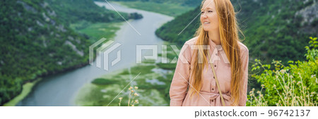 BANNER, LONG FORMAT Woman tourist in the background Canyon of Rijeka Crnojevica river near the Skadar lake coast. One of the most famous views of Montenegro. River makes a turn between the mountains 96742137