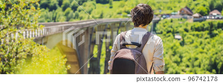 BANNER, LONG FORMAT Montenegro. Man tourist in background of Dzhurdzhevich Bridge Over The River Tara. Travel around Montenegro concept. Sights of Montenegro Portrait of a disgruntled girl sitting at 96742178