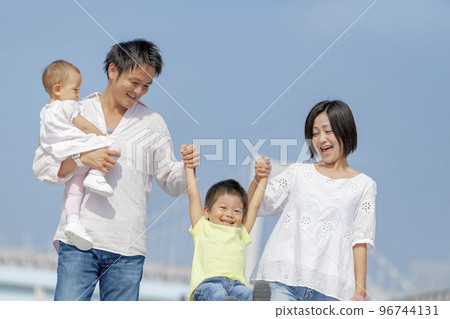 Four people walking on the boardwalk 96744131