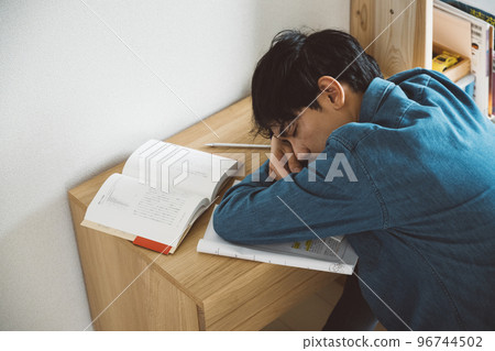 A man who studies and falls asleep 96744502