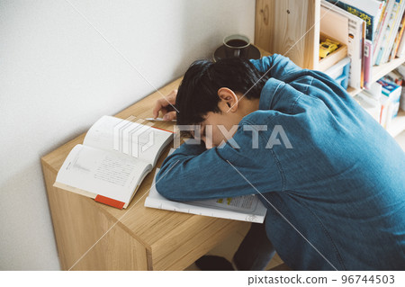 A man who studies and falls asleep 96744503