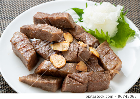 Bite-sized steak served with grated daikon radish. 96745065