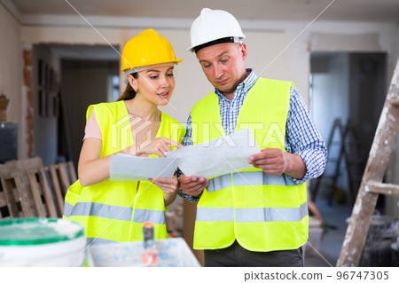 Woman engineer and man architect talking about documents Woman engineer and man architect talking about documents 96747305