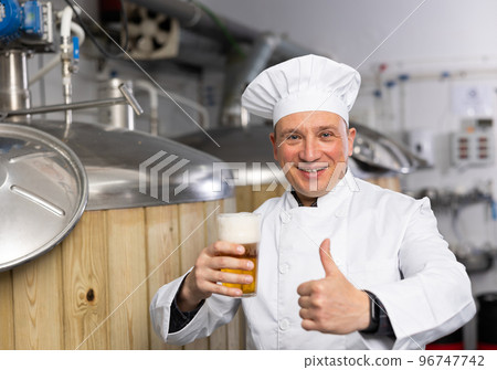 Portrait of positive man brewmaster with glass of beer Portrait of positive man brewmaster with glass of beer 96747742