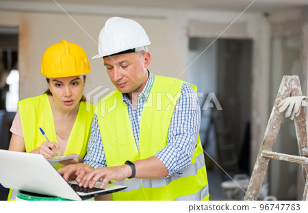 Man and woman engineers using laptop Man and woman engineers using laptop 96747783