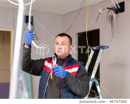 Worker repairing wires while installing electricity 96747860
