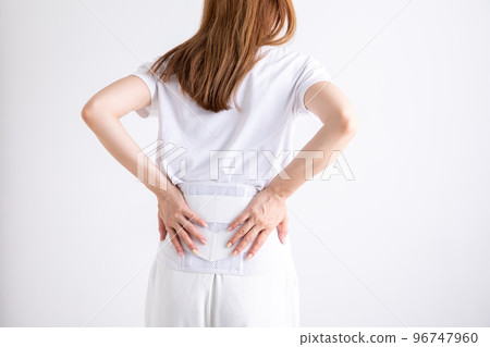 A woman wearing a belt for low back pain A woman wearing a belt for low back pain 96747960