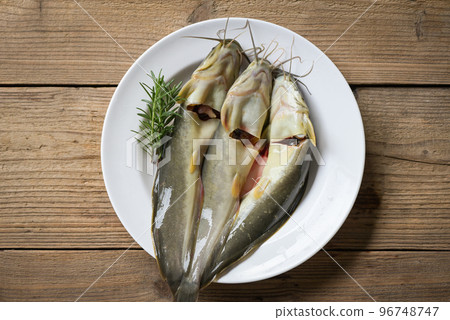 catfish on plate, fresh raw catfish freshwater fish, catfish for cooking food, fish with ingredients herb rosemary on wooden background catfish on plate, fresh raw catfish freshwater fish, catfish for cooking food, fish with ingredients herb rosemary on wooden background 96748747