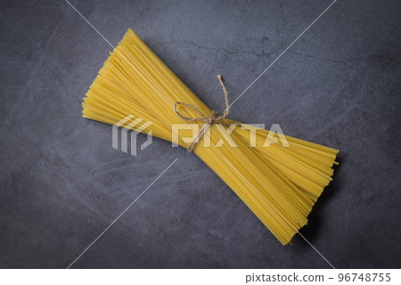 Raw spaghetti pasta uncooked, spaghetti noodles on dark background, raw pasta italian food 96748755