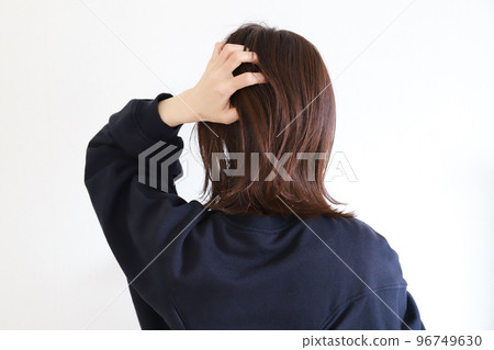 一個女人撫摸她的頭髮的背影 一個女人撫摸她的頭髮的背影 96749630