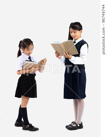 Junior school girl uniform standing and reading book full length white background. 96749744